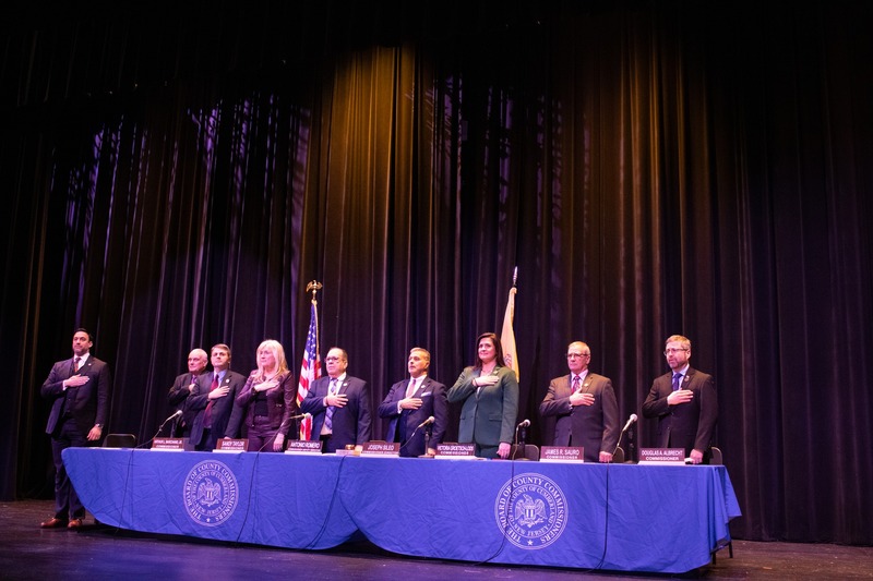 commissioners standing with hands over hearts